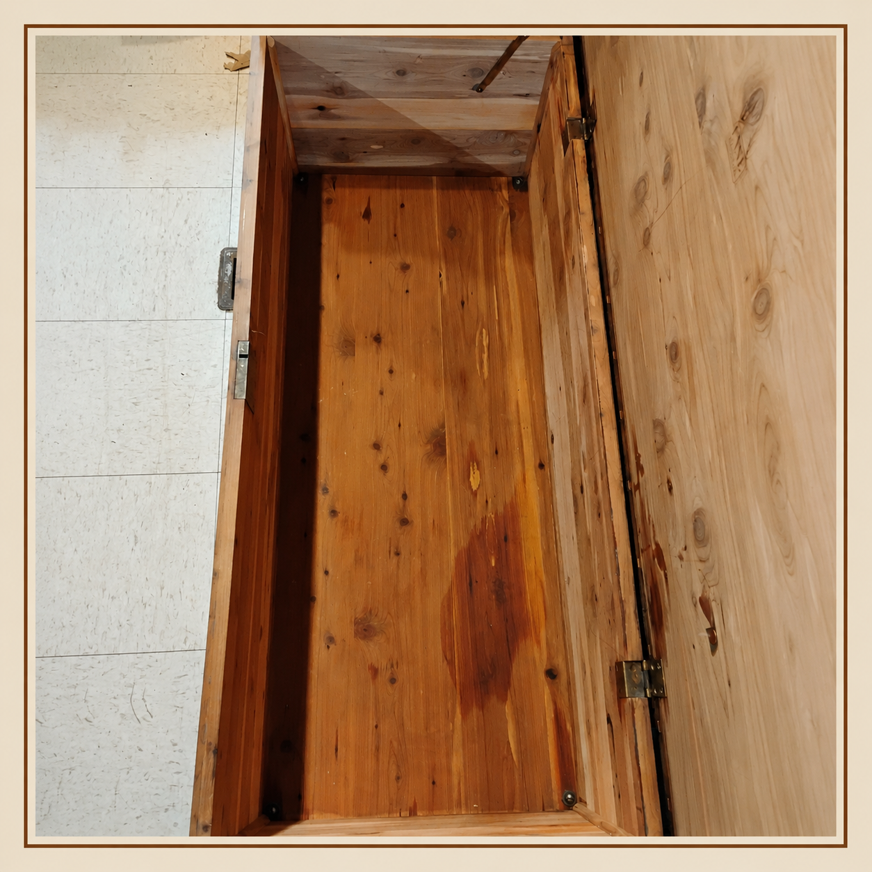 Interior of vintage Lane cedar chest showing cedar-lined storage area, wood grain, hardware, and age-related wear.