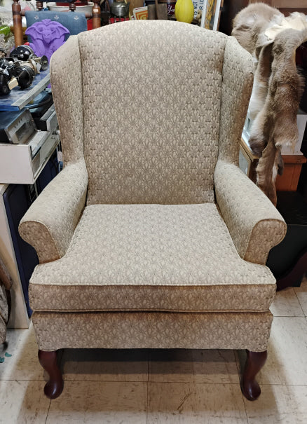 Patterned armchair in a room with various items in the background